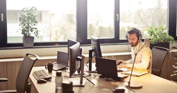 man-with-headphones-facing-computer-monitor-845451